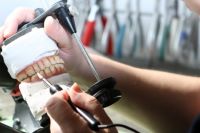 Zahntechniker bei der Arbeit an einem Gebiss-Modell