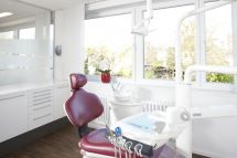 Behandlungszimmer mit Behandlungsstuhl und Geräten